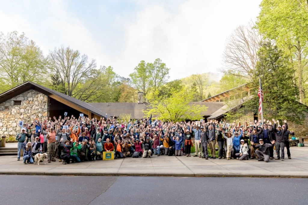 Group of volunteers posing in front of the Ranger Station, excited to get to work in the forest